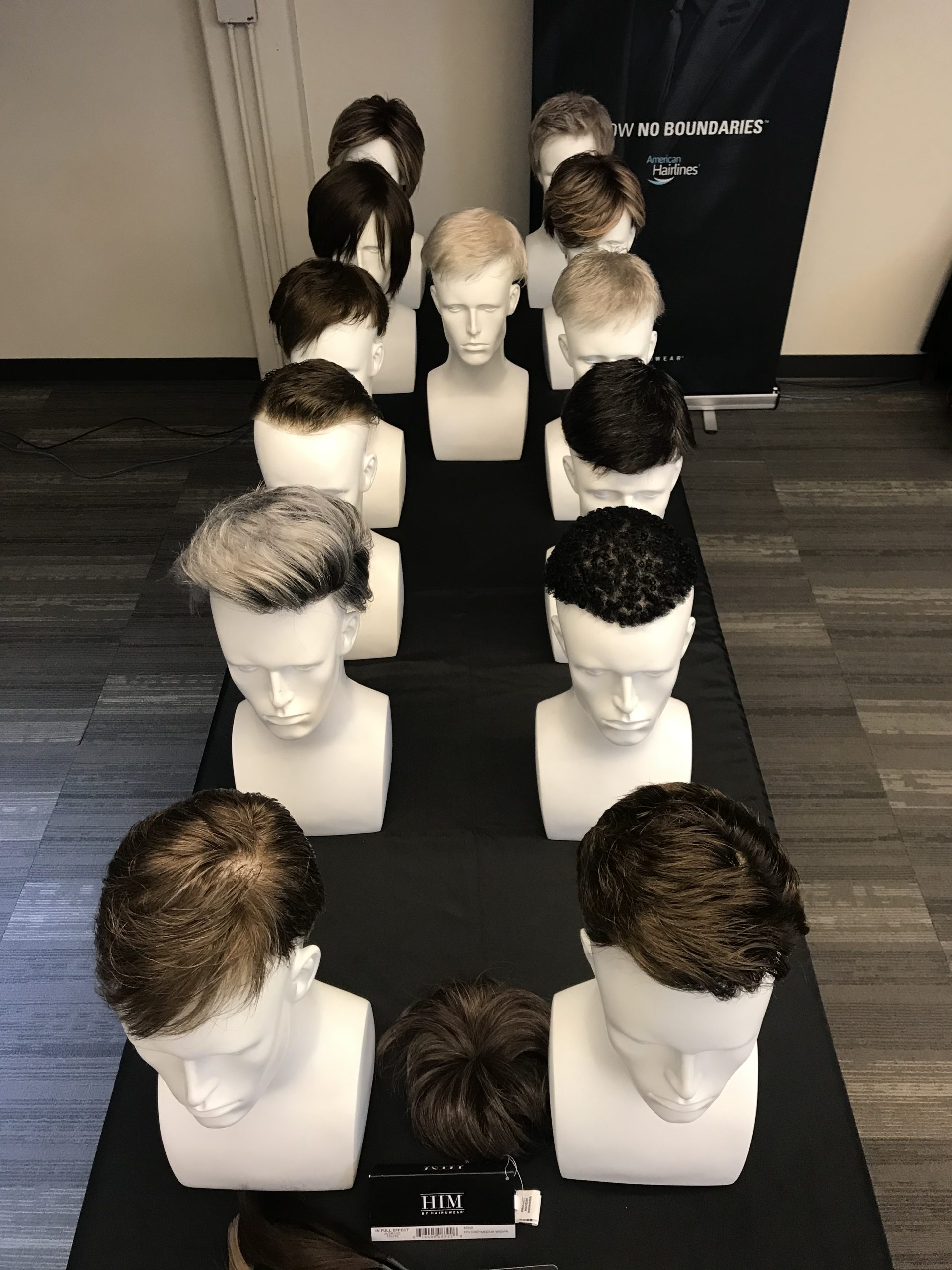 a row of mannequin heads with different hair styles